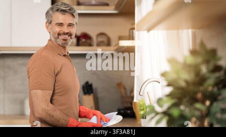 Smiling Caucasian Man Washing Dishes In Modern Kitchen, Household Chores Concept Stock Photo