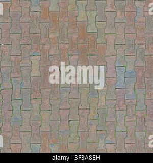 Directly above view of reddish interlocking dumbbell concrete paver stones with slight vegetation growth. Stock Photo