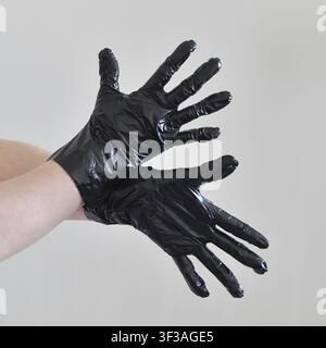 Two female hands in black plastic gloves with a spread fingers Stock Photo