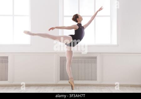 Beautiful young ballerina stands in ballet arabesque Stock Photo