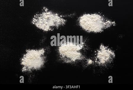Sprinkled wheat flour splash spots on black background Stock Photo