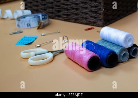 Colorful Sewing Threads Measuring Tape and Needle on Tailor Table Stock Photo