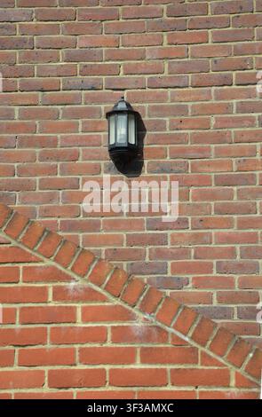 UK East Sussex, Eastbourne, Sovereign Harbour traditional black outdoor wall lantern mounted on a red brick exterior wall Stock Photo