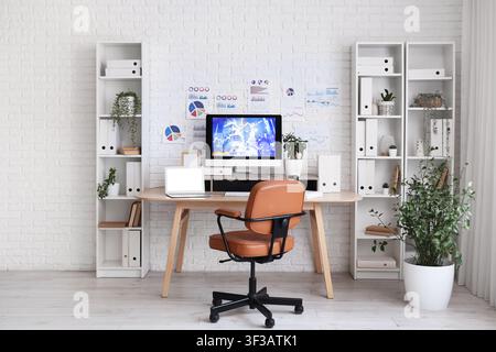 Interior of data scientists office with workplace, diagrams and shelf units Stock Photo
