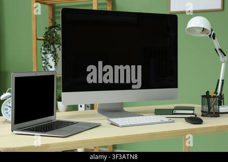Programmers workplace with blank laptop and computer in office Stock Photo