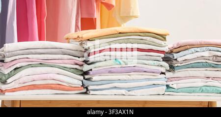 Stacks of folded colorful t-shirts on table Stock Photo