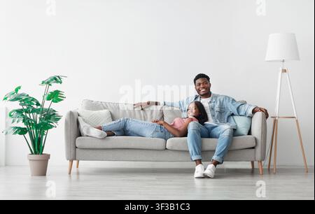 African american couple spending weekend together lying on couch Stock Photo