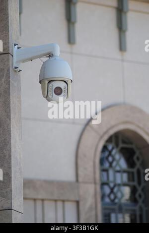 Security camera mounted on building wall in city area Stock Photo