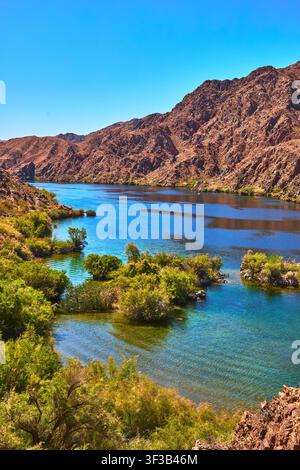 Colorado River Flowing Through Desert Landscape With Lush Green Vegetation Stock Photo