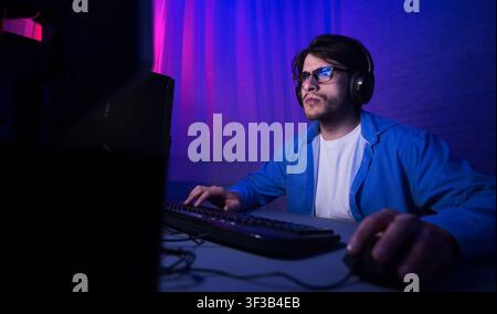 Gaming concept. Pro gamer playing shooter video game Stock Photo