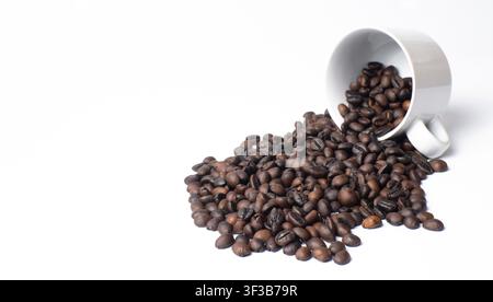 Roasted Coffee Beans Spilling from White Cup Isolated on White Background Stock Photo