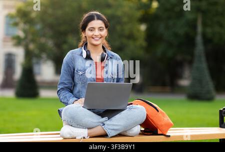 Relaxed woman student studying outdoors with laptop Stock Photo