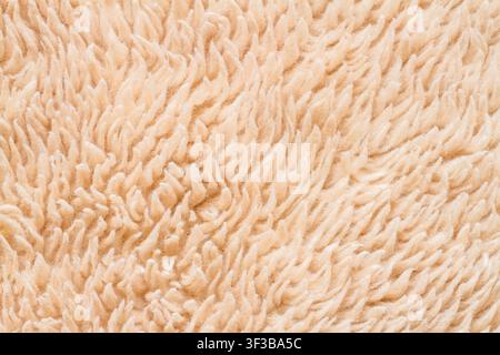 The texture of faux fur is peach colored. Faux fur close-up. Stock Photo