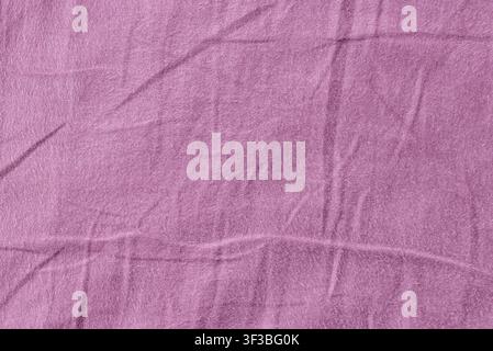 Minimalist textured textile banner featuring a wrinkled purple cloth. Purple crumpled fabric background with soft folds and copy space. Stock Photo