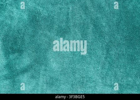 Vibrant turquoise terry towel fabric texture background with copy space. Bright cyan plush textile texture background with space for text. Stock Photo