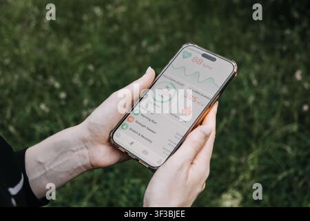 Hands hold smartphone displaying health and fitness application dashboard outdoors. personalized medicine technology, Self tracking health data Stock Photo