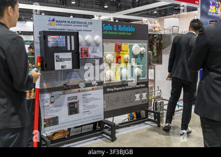 Bangkok, Thailand - July 22, 2026: Attendees viewing fire alarm control panels, smoke detectors, and wiring diagrams at a fire safety engineering boot Stock Photo