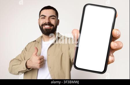 Millennial Man Holding Smart Phone With White Screen Stock Photo