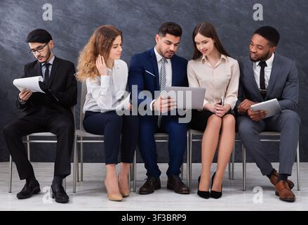 Diverse young businesspeople using laptops and smartphones Stock Photo