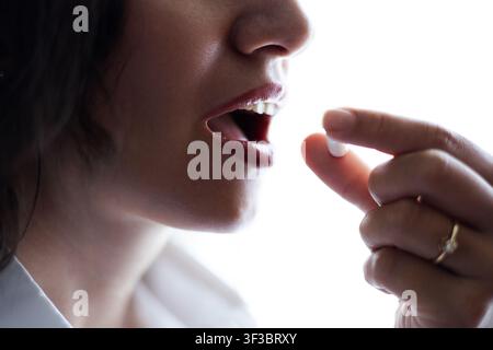 Close-up of a woman taking pills Stock Photo