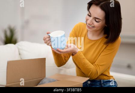 Young brunette woman holding blue china mug Stock Photo