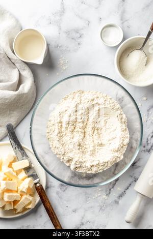 Process of making a base for shortbread pie, tart or quiche. Flour in glass bowl and other ingredients for the dough. Home baking, recipe. Flat lay, v Stock Photo