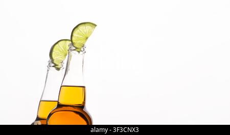 Transparent beer bottles with light drink with lime slices, cropped, isolated on white background Stock Photo