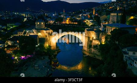 Aerial view of a long bridge illuminated at dusk stretching across the ...