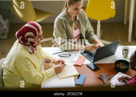 Diverse Women Collaborating on Laptop for Team Planning Meeting Stock Photo