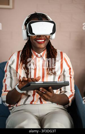 African American woman experiencing virtual reality using tablet Stock Photo