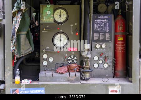 Munich, Bavaria, Germany - June 6, 2026: The control panel and fittings of a Bundeswehr military fuel truck, featuring gauges, valves, hoses, and a fire extinguisher. The open technical compartment is used for fuel supply and logistics *** Bedienfeld und Armaturen eines militärischen Tankfahrzeugs der Bundeswehr mit Anzeigen, Ventilen, Schläuchen und Feuerlöscher. Die geöffnete Techniksektion dient der Kraftstoffversorgung und Logistik Stock Photo