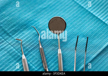 Dental examination instruments arranged on sterile blue dental bib Stock Photo
