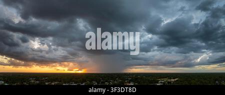 Rain shower water pouring down from stormy clouds during summer thunderstorm in rural Florida at sunset Stock Photo