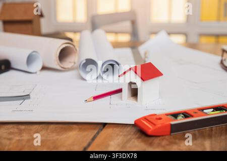 Architects house model with measurement tool and blueprints on architect desk. A architects home model with plan and blueprints. Business, architectur Stock Photo