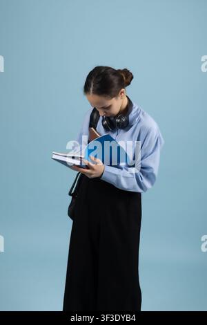 Smart young businesswoman writing notes in folder tablet taking records Stock Photo