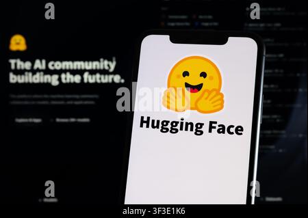 Paris, France - July 23, 2026 : A smartphone showing the logo of Hugging Face in front of a computer screen displaying the company website. Stock Photo
