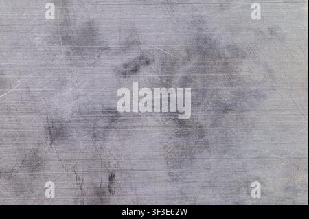 Close-up of scratched brushed metal surface with industrial grunge texture. Stock Photo