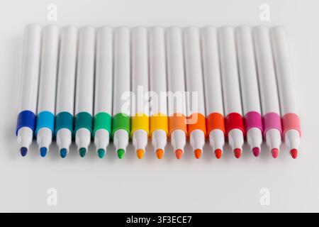 Top view of colorful felt tip pens arranged in a row gradient on white backgroundTop view of colorful felt tip pens arranged in a row gradient on whit Stock Photo