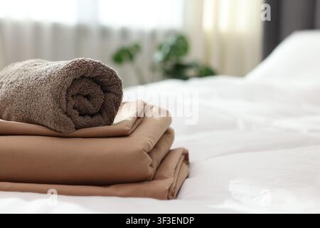 Home textile. Terry towel and linens on bed indoors, closeup. Space for text Stock Photo