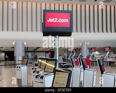 MANCHESTER, UK - JUNE 21 2026: A prominent overhead screen displaying the Jet2.com logo above automated self-service check-in kiosks and bag drop desk Stock Photo