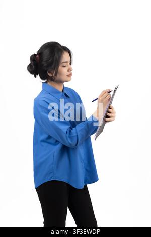 Businesswoman in blue shirt holding clipboard taking notes with pen Stock Photo