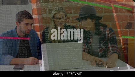 Woman in fedora reaching keyboard, showing code overlay while team debugging laptop for tech review Stock Photo