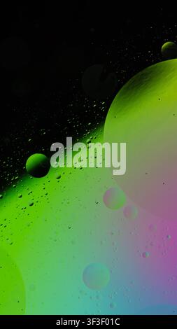 Oil and water creating vibrant green, pink, and blue abstract bubbles and spheres Stock Photo