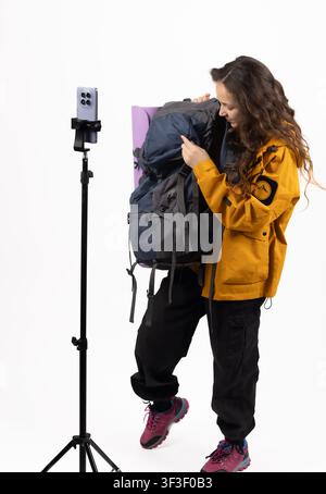 Female backpacker recording video blog on smartphone mounted on tripod Stock Photo