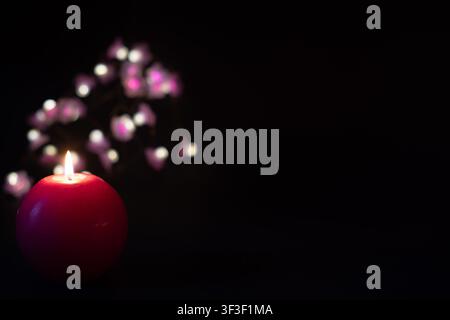 Red candle with festive bokeh lights on dark background, celebration concept with copy space Stock Photo
