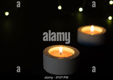 Two candles with festive bokeh lights on dark background, celebration concept with copy space Stock Photo