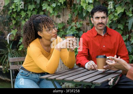 Friends enjoying coffee and conversation outdoors Stock Photo