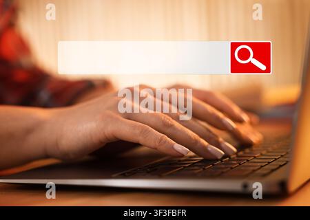 Search bar and woman using laptop at table. Closeup view Stock Photo