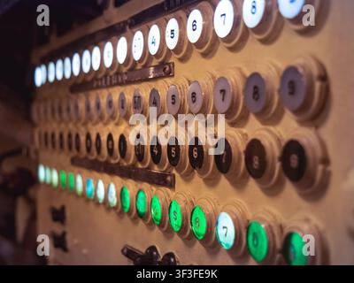 Rows of numbered vintage push-button switches and indicator lights on a worn submarine control panel Stock Photo