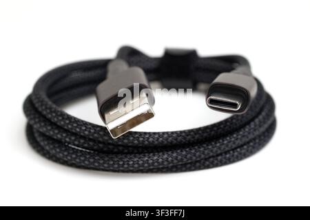 usb-a to usb-c cable coiled, showing both connectors on white background Stock Photo